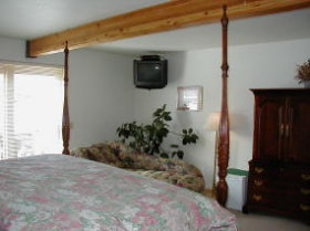 A cozy king room with a 4-post bed, and down comforter